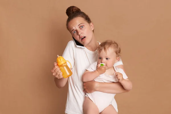 Image Shocked Surprised Mother Baby Daughter Holding Bottle Water Talking — Stock Photo, Image