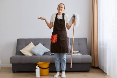 Çekici, sevimli, gülümseyen, yerleri paspasla yıkayan, umutsuz bir ifadeyle daireyi temizleyen, omuzlarını silkeleyen, dişlek tebessümle kameraya bakan bir kadın resmi..