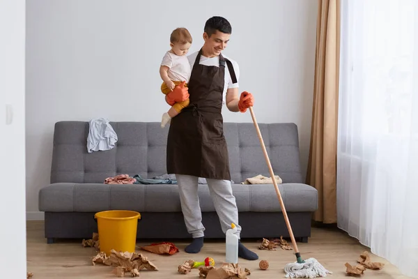 머리를 남자의 걸레로 바닥을 집안일을 아파트를 청소하고 자기딸을 아이를 돌보는 — 스톡 사진