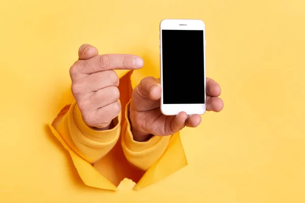 Image Person Hand Breaking Yellow Paper Holding Smart Phone Pointing — Stock Photo, Image