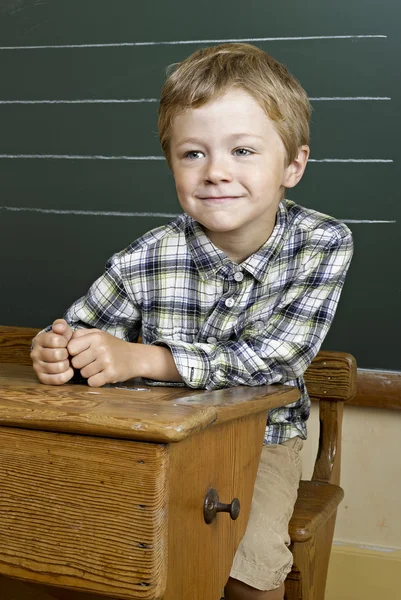 Πορτρέτο του χαριτωμένο αγόρι μπροστά από ένα μαυροπίνακα. — Φωτογραφία Αρχείου
