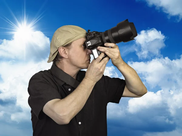 Άνθρωπος που πραγματοποιήθηκε κάμερα μπλε ουρανό — Φωτογραφία Αρχείου