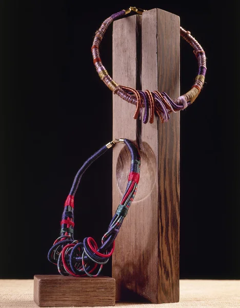 Два ожерелья на деревянном блоке — стоковое фото