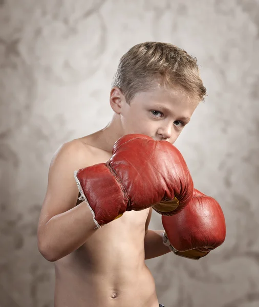 Non Aggressive child wearing boxing gloves on textured backgroun — Stock Photo, Image
