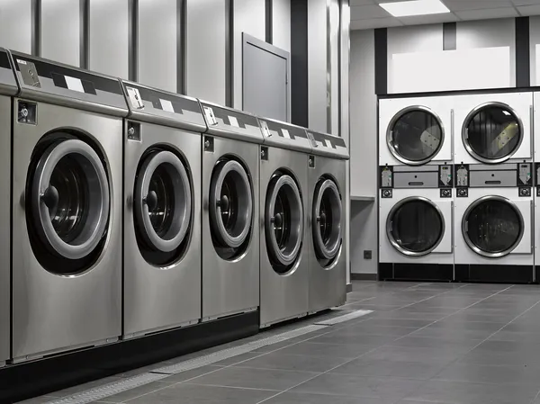 Een rij industriële wasmachines in een openbare wasserette — Stockfoto