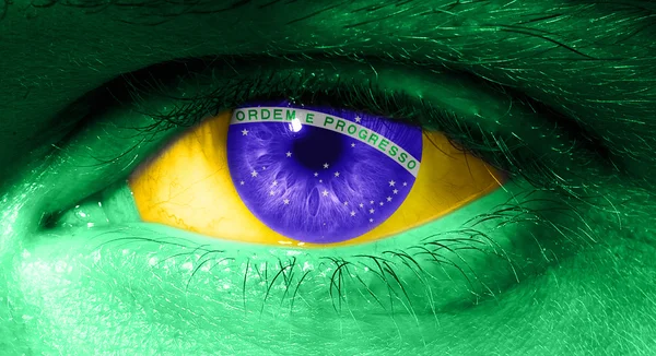 Закрыть человеческий глаз флагом Бразилии — стоковое фото