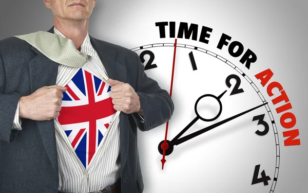 Επιχειρηματίας προβολή πουκάμισο με σημαία από το Ηνωμένο Βασίλειο κοστούμι ενάντια ρολόι — Φωτογραφία Αρχείου