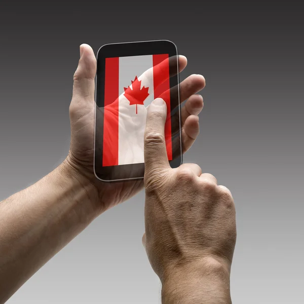 Holding kanadai zászló képernyőn okostelefonok — Stock Fotó