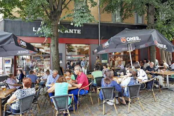 Människor dricka, äta och tala på ett kafé terrass — Stockfoto