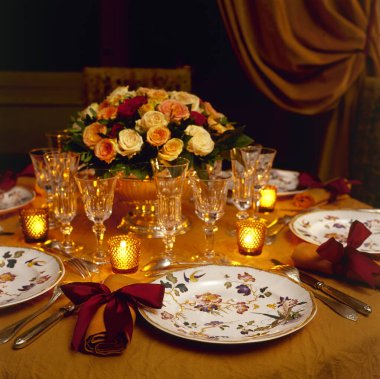 Bir vazo ve şık bir buket çiçekle şenlikli bir düğün masası. İlk tabağa odaklan.