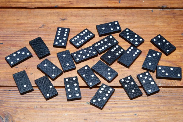 一些黑色多米诺骨牌在闷热的木桌上 — 图库照片