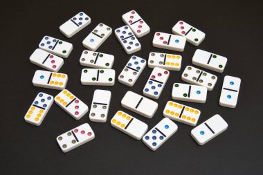 Siyah masada bir sürü domino taşı var.