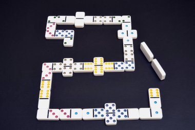 Siyah masada bir sürü domino taşı var.