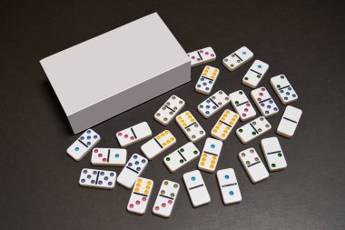 Boş kutu ve domino taşları siyah masada.