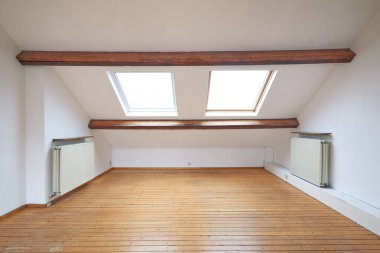 İç tavan arası pencereleri ve boş odada ahşap döşemeler.