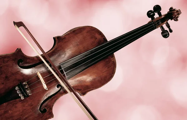 小提琴身的细节和红色模糊背景下的弓 — 图库照片