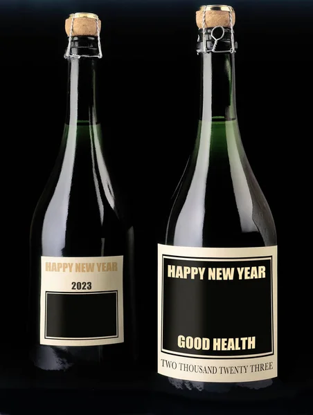 Two bottle of champagne with black label on black background. Greetings for new year 2023