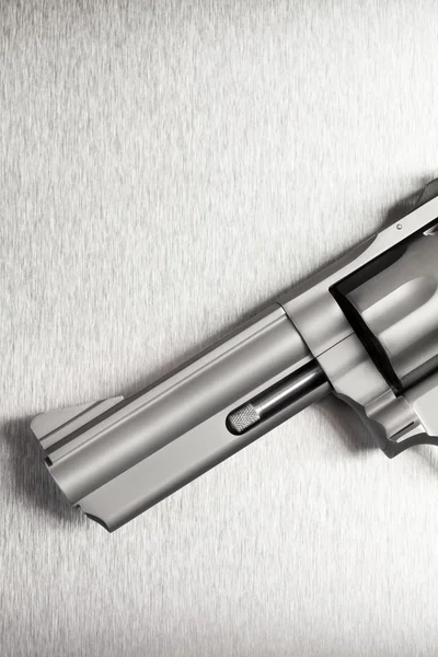 Pistola no fundo de metal escovado — Fotografia de Stock