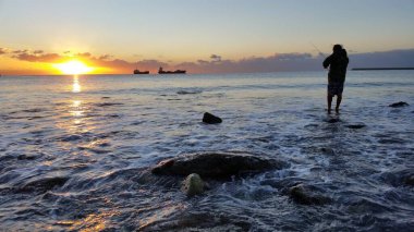 The fisherman at sunrise on the sea