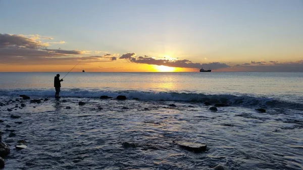 The fisherman at sunrise on the sea