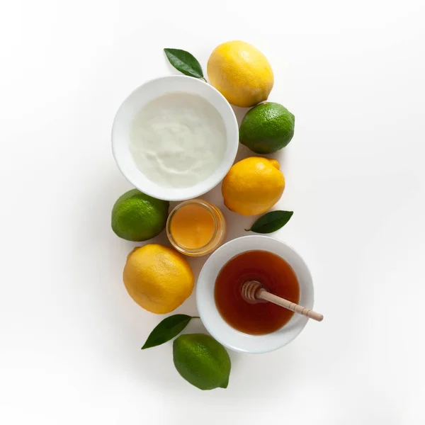 Yogurt with honey and lemon on white background from top view. Flat lay