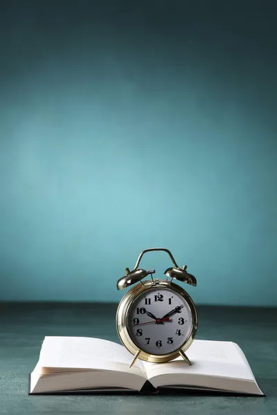 Alarm clock on open book — Stock Photo, Image