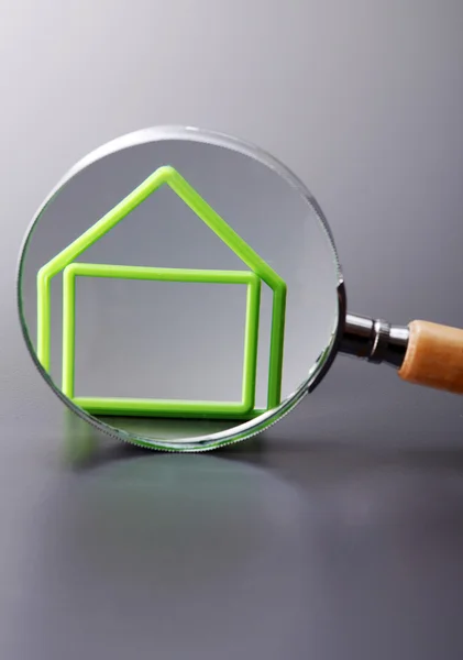 Magnifying glass and model of house — Stock Photo, Image
