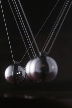 A chrome ball on a newtons cradle out of align clipart