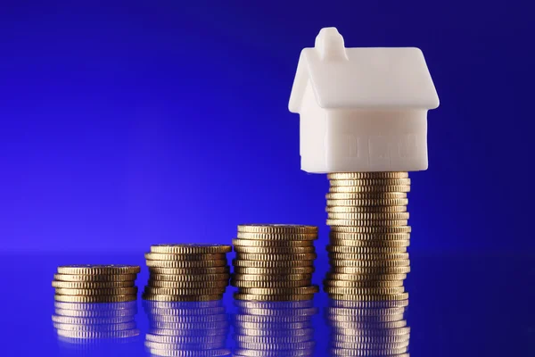 Close-up of a model home on a pile of coins — Stock Photo, Image