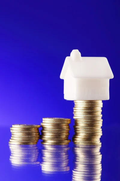 Close-up of a model home on a pile of coins — Stock Photo, Image