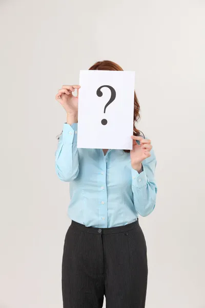 büyük bir soru işareti basılı bir kağıt tutan kadın