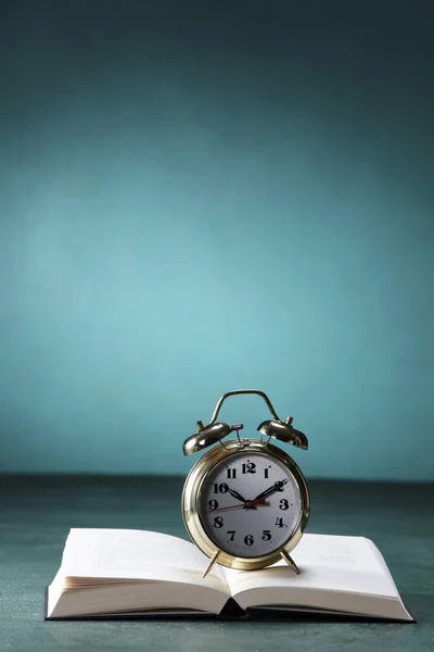 Alarm clock on open book — Stock Photo, Image