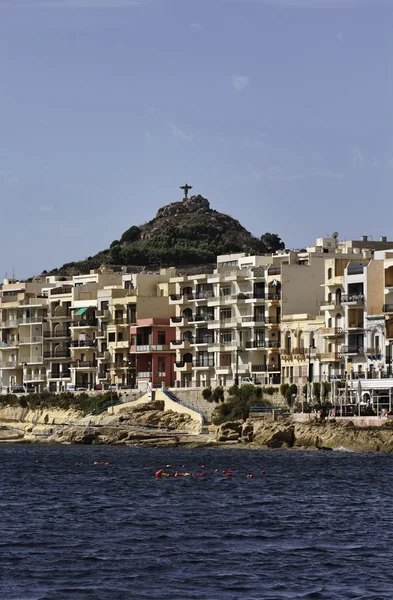 Μάλτα, Γκόζο νησί, marsalforn πόλη, κτίριο από τη θάλασσα και ένα άγαλμα του Ιησού στο λόφο — Φωτογραφία Αρχείου