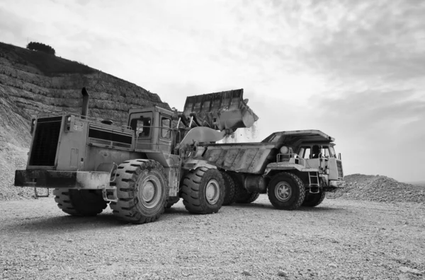 Stenen put met industriële voertuigen op het werk — Stockfoto