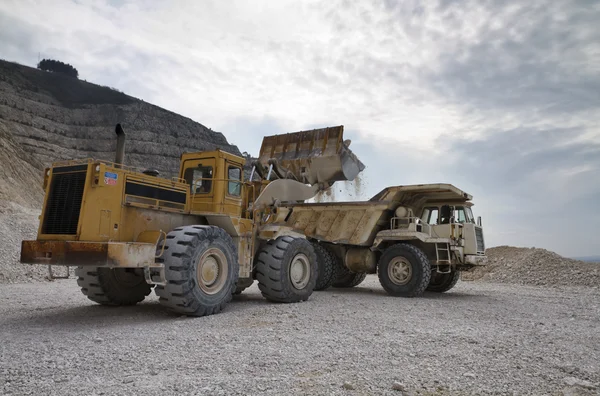 Steingruve med industrikjøretøyer på arbeidsplassen – stockfoto