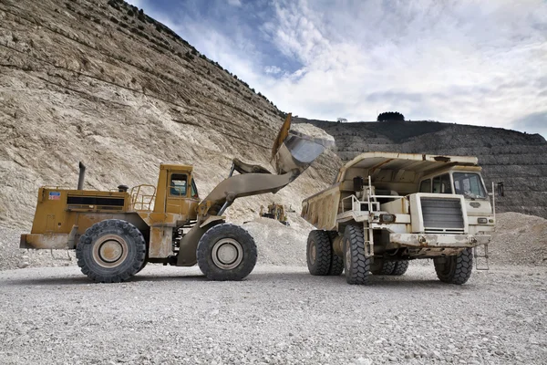 Stone pit with industrial vehicles at work — Stock Photo, Image