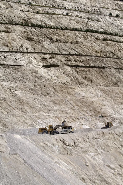 Stone pit with industrial vehicles at work — Stock Photo, Image