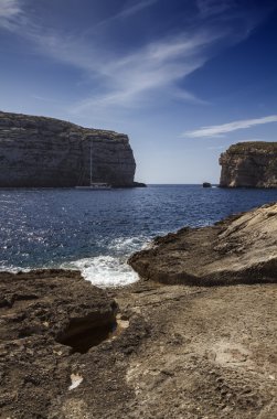 azure pencere rock Malta Adası, gozo, dweira lagoon, bir yelkenli tekne ve kayalık sahil yakınındaki