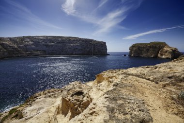 azure pencere rock Malta Adası, gozo, dweira lagoon, yelkenli tekne görünümünü ve kayalık sahil yakınındaki