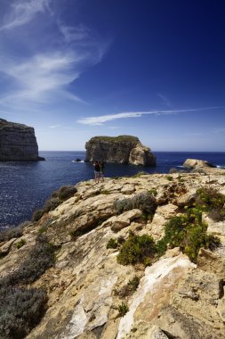 Malta Adası, gozo, dweira lagoon, turistler zevk azure pencere rock yakınındaki kayalık sahil şeridi görünümü