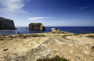 Malta Adası, gozo, dweira lagoon, turistler zevk azure pencere rock yakınındaki kayalık sahil şeridi görünümü