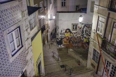 Portugal, Lisbon, Alfama area, view of a small street and a Fado mural at night clipart