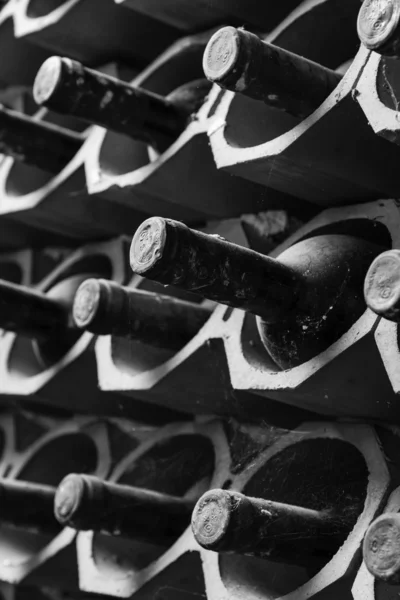 Old red wine bottles aging in a wine cellar — Stock Photo, Image