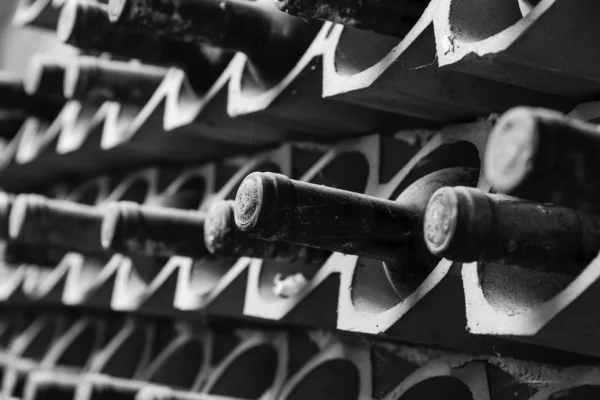 Старі червоні пляшки вина, що старіють у винному підвалі — стокове фото