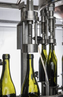 İtalya, Sicilya, şarap şişeleri ile şarap şarap fabrikasında bir sanayi makinesi tarafından doldurulur.