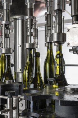İtalya, Sicilya, şarap şişeleri ile şarap şarap fabrikasında bir sanayi makinesi tarafından doldurulur.
