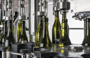 İtalya, Sicilya, şarap şişeleri ile şarap şarap fabrikasında bir sanayi makinesi tarafından doldurulur.
