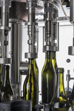 İtalya, Sicilya, şarap şişeleri ile şarap şarap fabrikasında bir sanayi makinesi tarafından doldurulur.