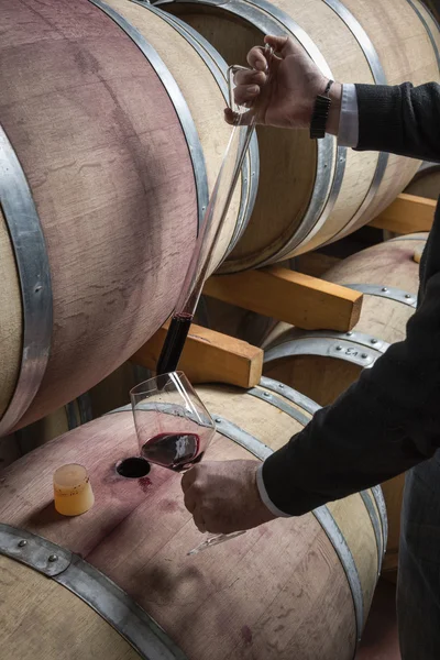 Italia, Sicilia, vino rosso versato da una botte di legno in un bicchiere in una cantina — Foto Stock