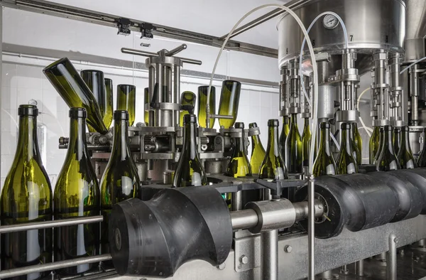 Italia, Sicilia, bottiglie di vino lavate e riempite di vino da una macchina industriale in una fabbrica di vino — Foto Stock